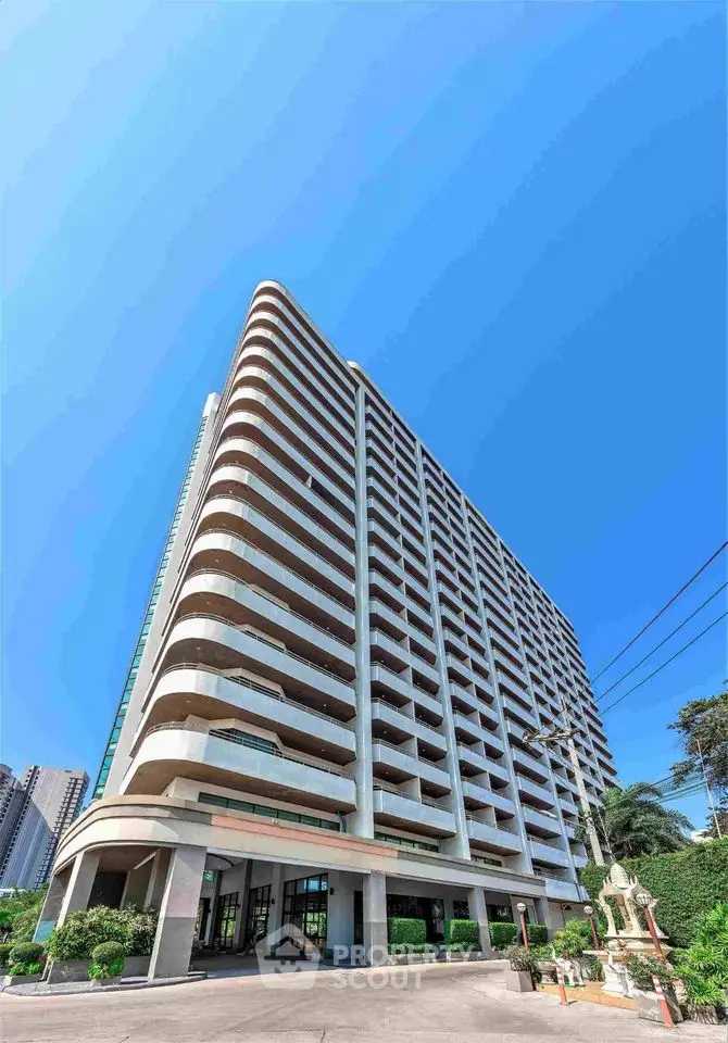 Modern high-rise building with spacious balconies and lush greenery