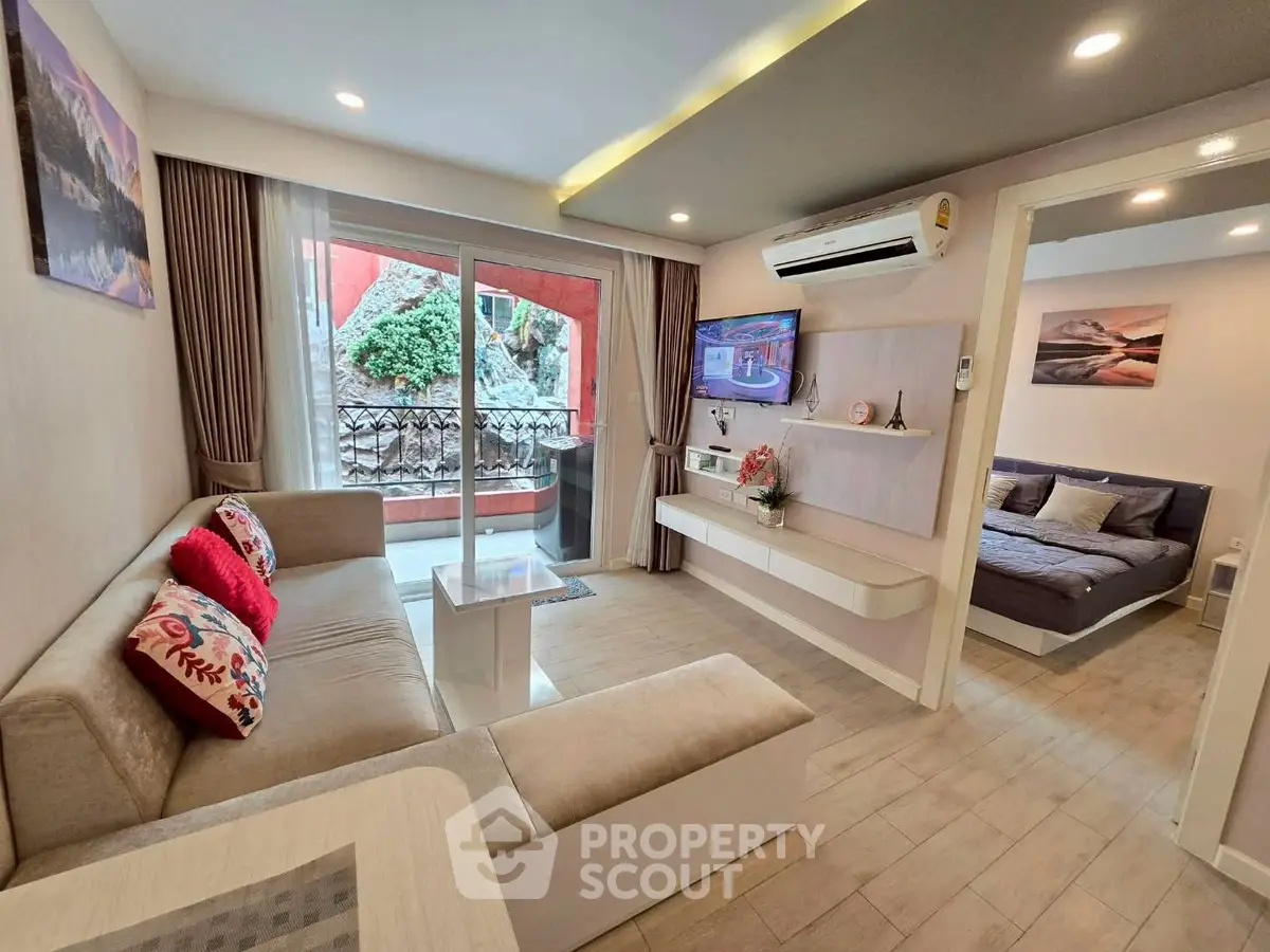 Modern living room with cozy sofa and TV, open to a stylish bedroom, featuring elegant decor and natural light.