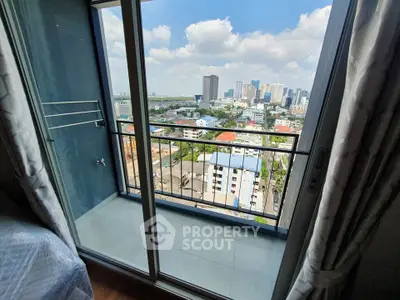 Stunning city view from a modern apartment balcony with glass doors and railing.