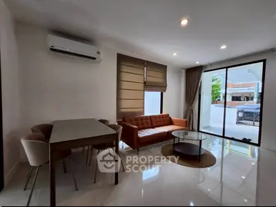Modern living room with sleek furniture and large windows offering natural light.