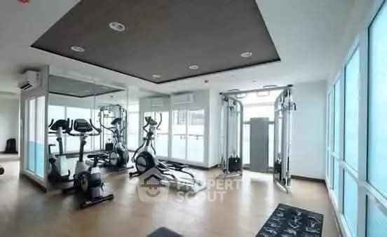 Modern gym with state-of-the-art equipment and large windows for natural light.