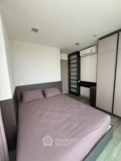 Modern bedroom with sleek design and ample storage in a contemporary apartment.