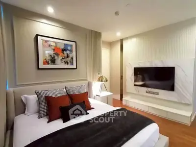 Luxurious modern bedroom with stylish decor and wall-mounted TV, perfect for relaxation.