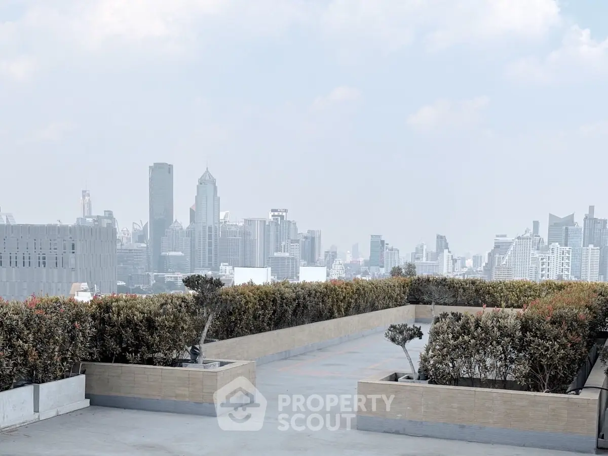 Stunning rooftop view of city skyline with lush greenery and open space.