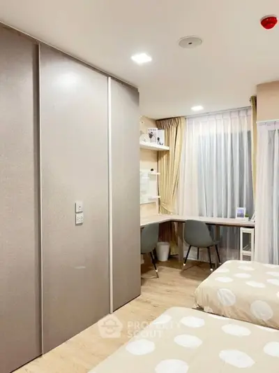 Modern bedroom with twin beds, study desk, and large closet in a bright, cozy apartment.