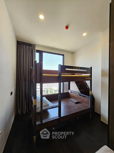 Modern bedroom with stylish bunk bed and large window offering city views.