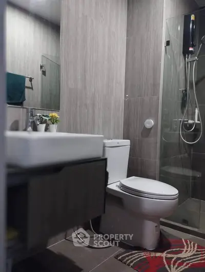Modern bathroom with sleek design, featuring glass shower and contemporary fixtures.