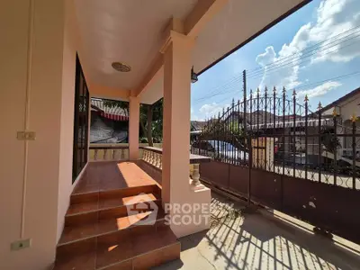 Charming home entrance with tiled steps and wrought iron gate, perfect for welcoming guests.
