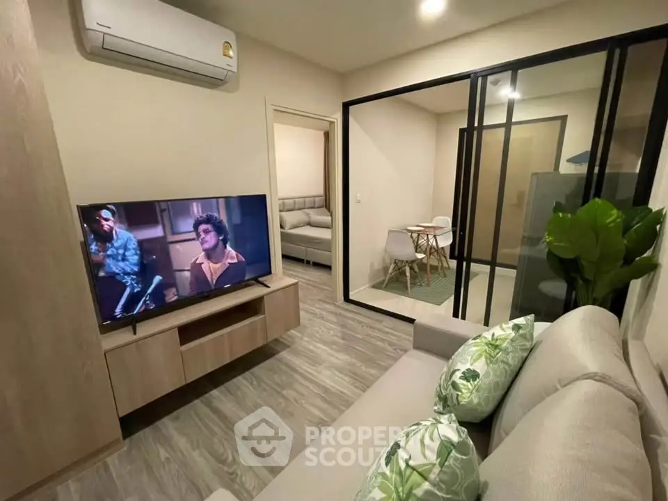 Modern living room with stylish decor and open layout, featuring a cozy sofa and wall-mounted TV.