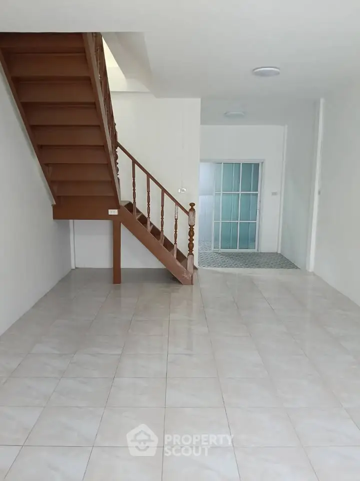 Spacious interior with elegant staircase and tiled flooring, perfect for modern living.