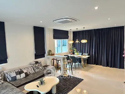 Modern living room with stylish decor and dining area, featuring cozy seating and elegant lighting.