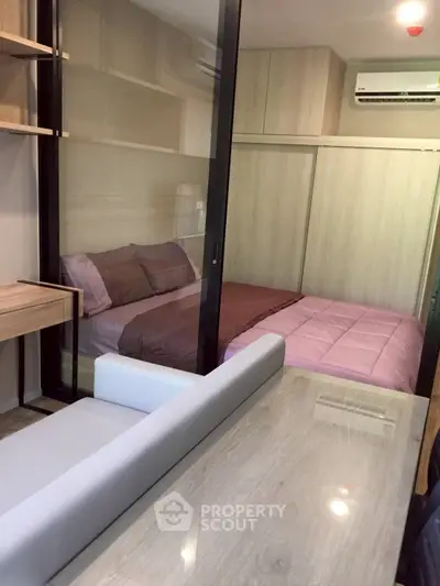 Modern compact bedroom with glass partition and stylish furnishings
