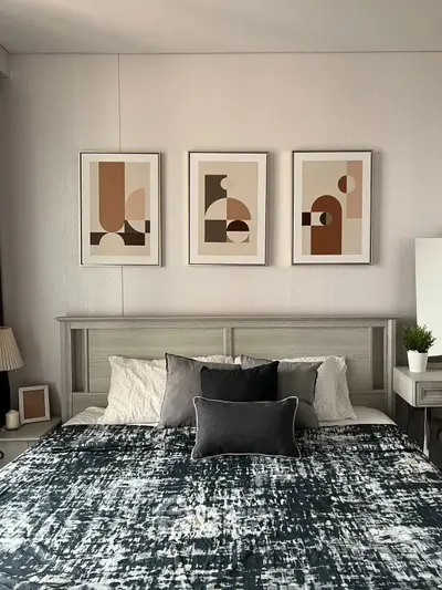 Modern bedroom with stylish decor and abstract art above bed