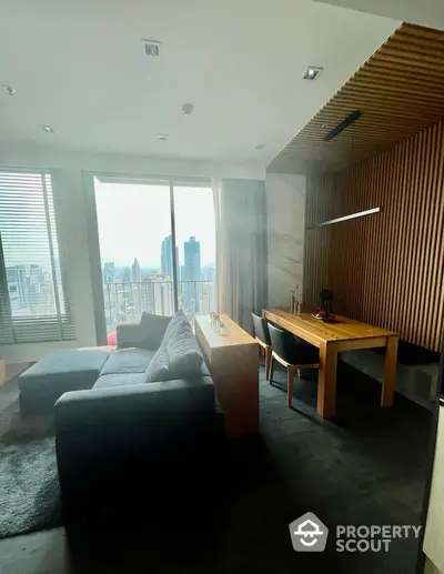 Spacious living room with modern furniture, wooden accents, and panoramic city views through floor-to-ceiling windows, ideal for urban living.