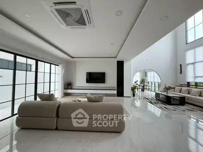 Spacious modern living room with elegant decor and large windows for natural light.