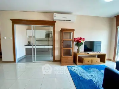 Spacious living room with modern decor and sliding glass doors to kitchen