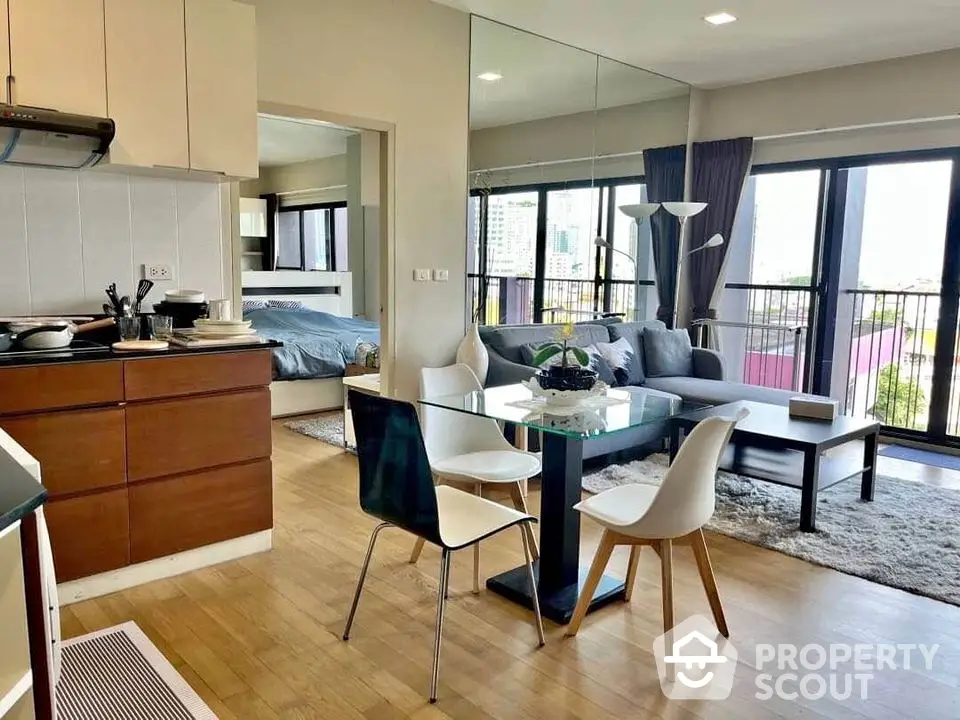 Modern open-plan living room with dining area and balcony view in urban apartment