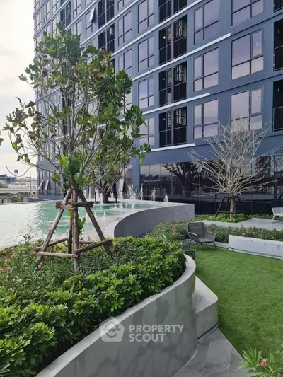 Modern building with lush garden and poolside area, perfect for luxury living.