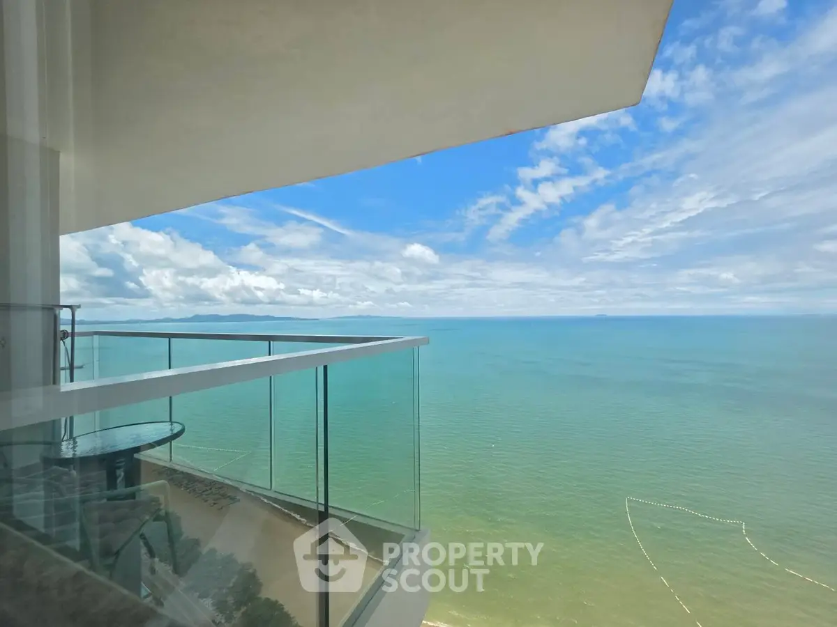 Stunning ocean view from a modern balcony with glass railing, perfect for relaxation and enjoying the sea breeze.