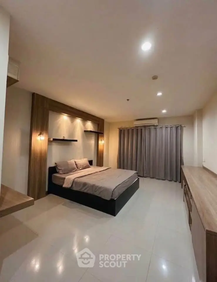 Spacious modern bedroom with elegant lighting and sleek furnishings