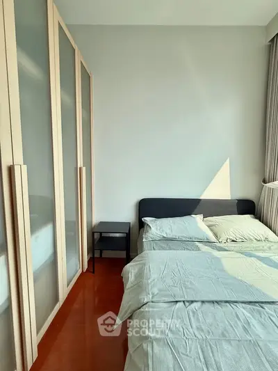 Modern bedroom with sleek wardrobe and cozy bed in natural light