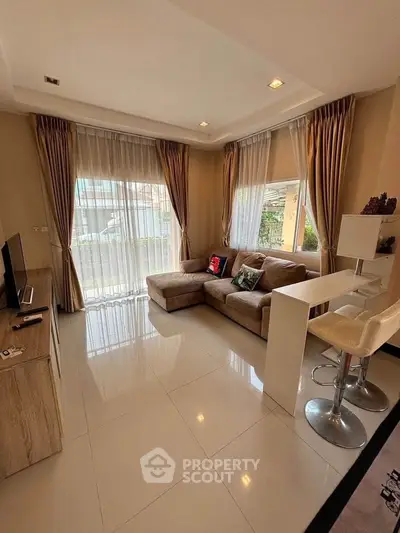 Modern living room with large windows and stylish furniture in a cozy apartment.