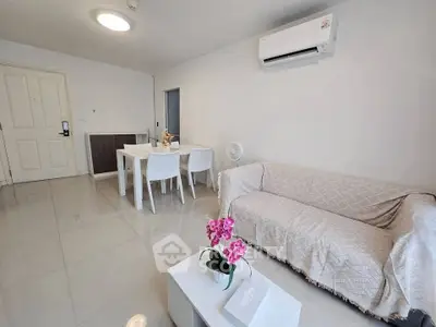 Modern living room with sleek white furniture and air conditioning, perfect for comfortable living.