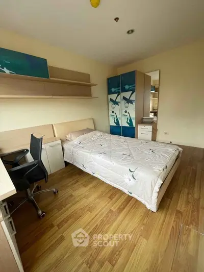 Cozy bedroom with wooden flooring, modern furniture, and ample storage space.