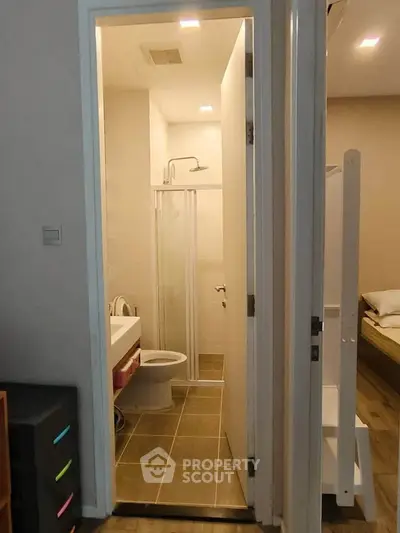 Compact bathroom with shower and modern fixtures in cozy apartment