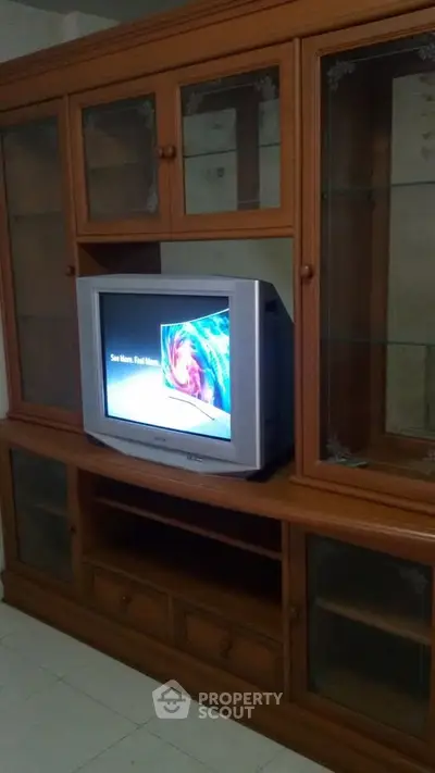Classic wooden entertainment center with vintage TV in cozy living room.