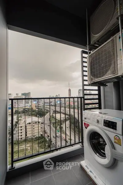 High-rise balcony with city view and washing machine, perfect for urban living.