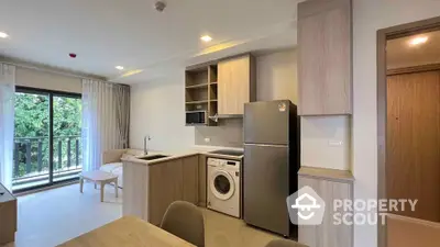 Modern open-layout kitchen with washing machine and balcony view