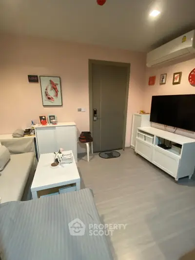 Cozy living room with modern decor and wall art, featuring a comfortable sofa and a flat-screen TV.