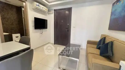 Modern living room with sleek furniture and wall-mounted TV in a cozy apartment.