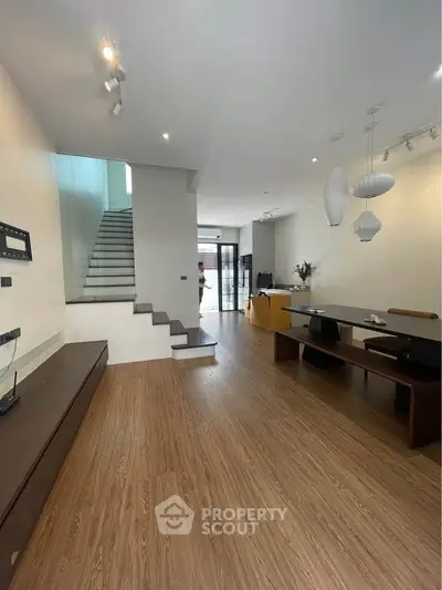 Spacious modern living room with wooden flooring and elegant lighting