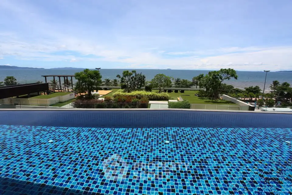 Luxurious oceanfront view from infinity pool with lush greenery and clear blue skies.