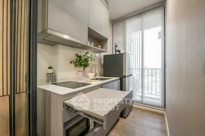 Modern compact kitchen with sleek design and open layout, featuring a balcony view.