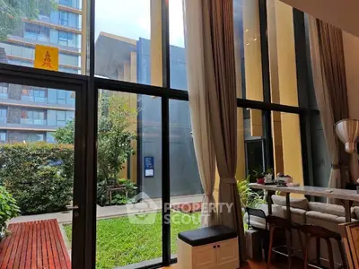 Spacious modern living room with floor-to-ceiling windows and garden view
