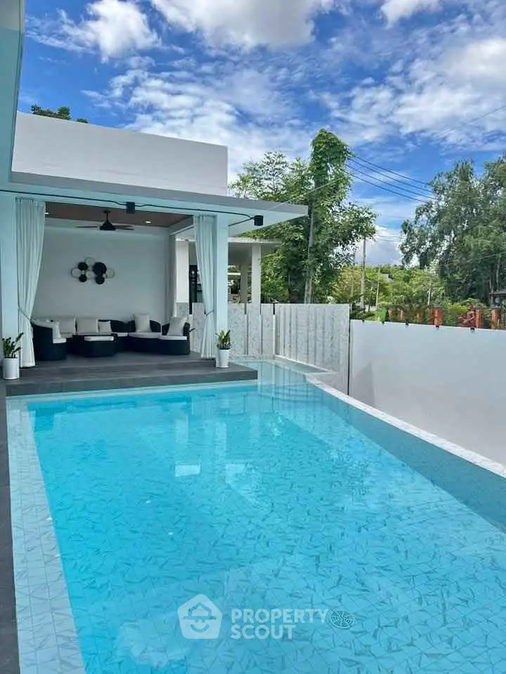 Luxurious modern home with stunning pool and outdoor lounge area, perfect for relaxation.