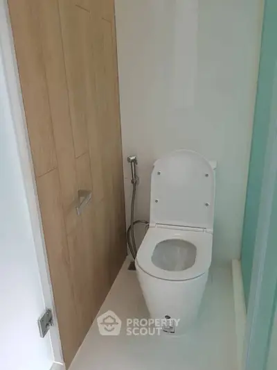 Modern bathroom with sleek toilet and wooden paneling, perfect for contemporary living spaces.
