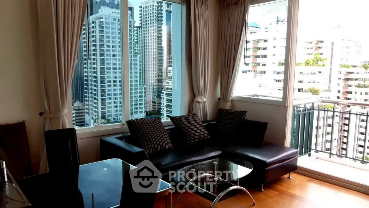 Spacious living room with stunning city view and modern furnishings in high-rise apartment.
