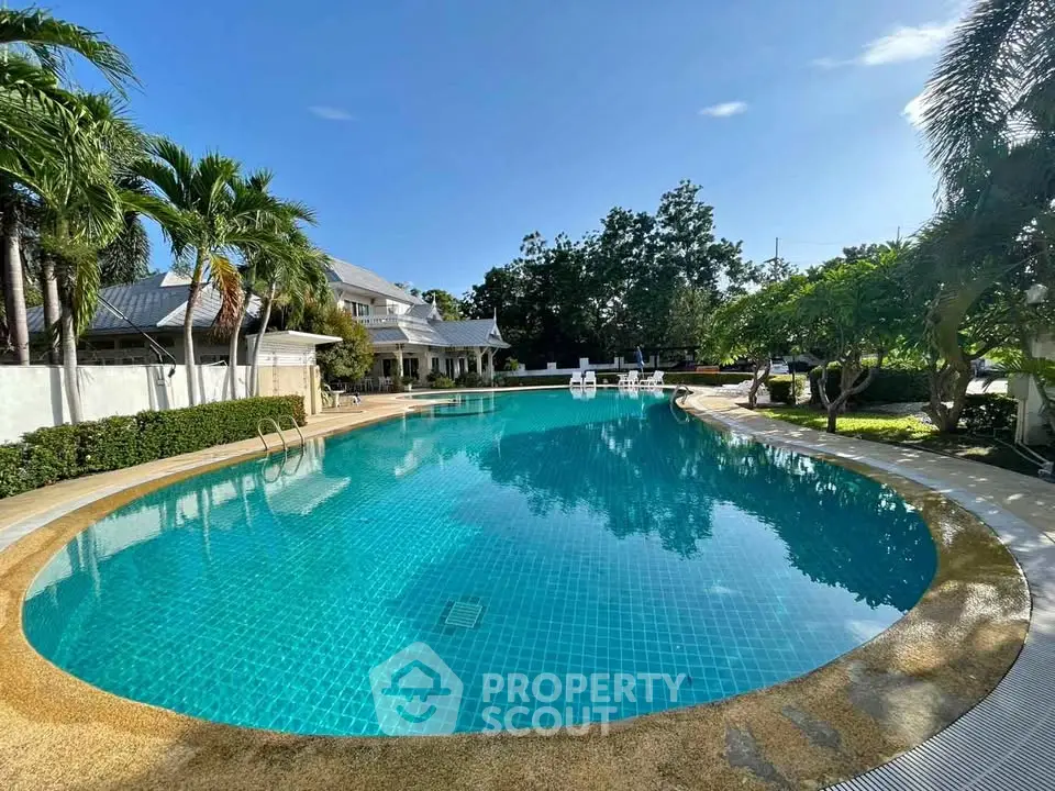Luxurious outdoor pool surrounded by lush greenery and elegant architecture, perfect for relaxation and leisure.
