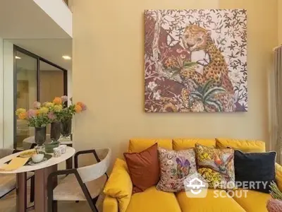 Stylish living room with vibrant yellow sofa and artistic wall decor