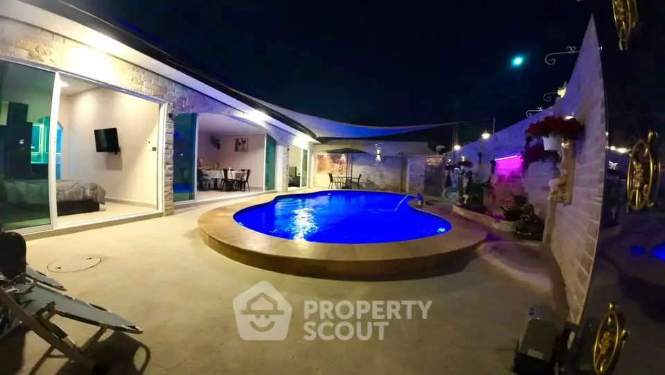 Luxurious night view of a modern home with illuminated pool and stylish outdoor area.