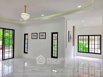 Spacious modern living room with marble flooring and large windows offering natural light.