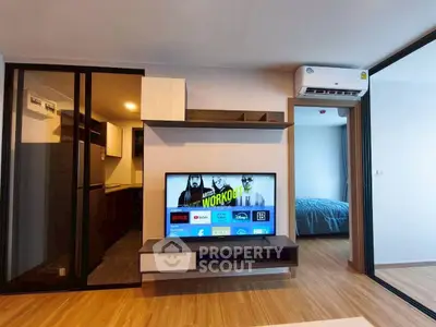 Modern living room with sleek TV setup and adjacent bedroom view