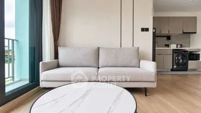 Modern living room with cozy sofa and stylish kitchen in open layout apartment.