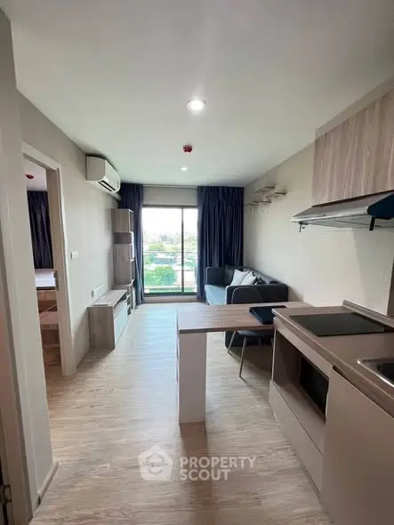 Modern open-layout living room with kitchen and balcony view