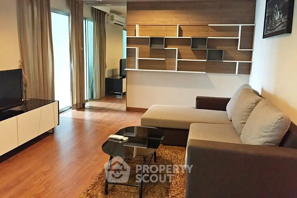 Modern living room with stylish shelving and cozy sofa in a contemporary apartment.