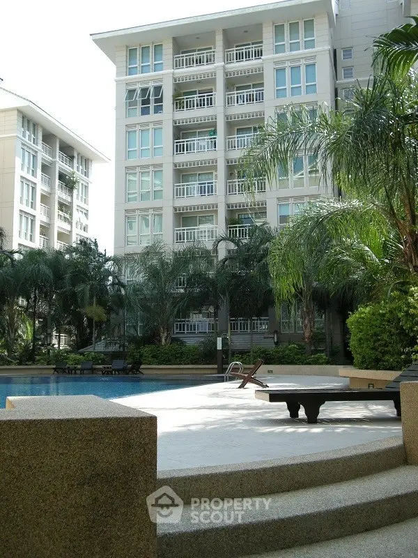 Luxurious residential building with pool and lush greenery, perfect for modern living.